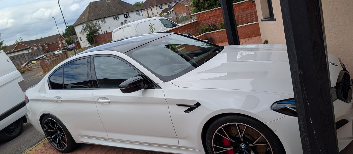 White BMW M5 with glossy paintwork on a residential driveway after a professional mobile valet