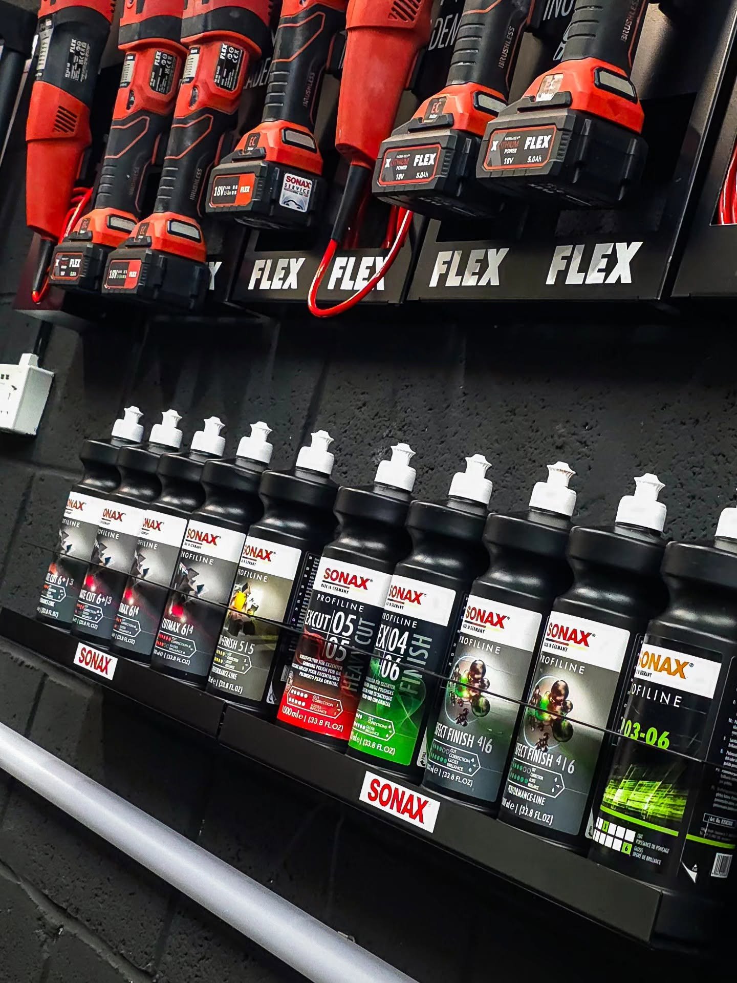 Sonax Profiline polishing compounds and Flex machine polishers lined up on a professional detailing wall