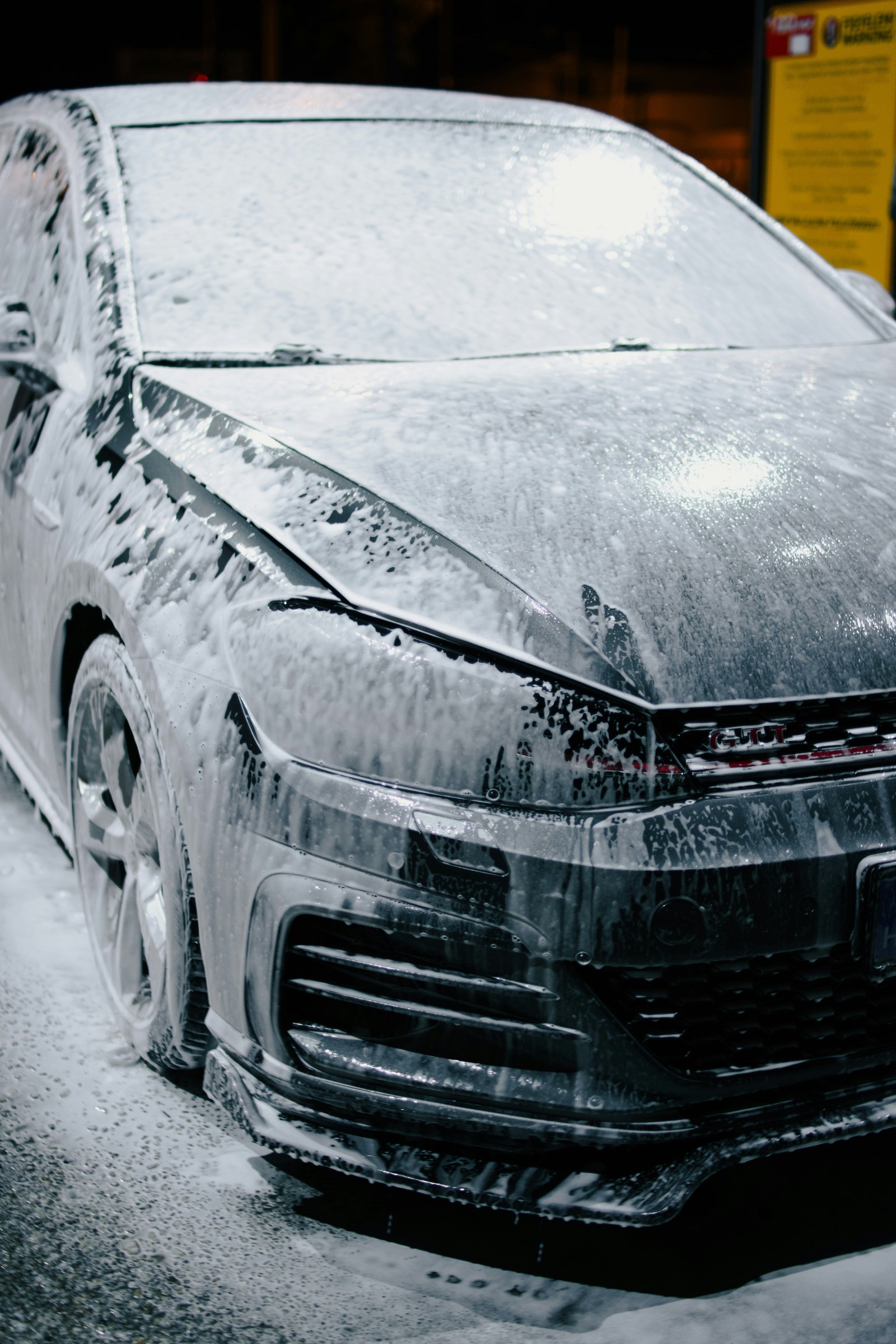 Car covered in snow foam during a professional safe wash process