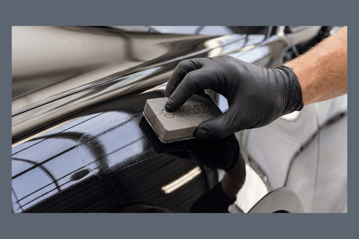 Professional detailer applying ceramic coating under controlled lighting