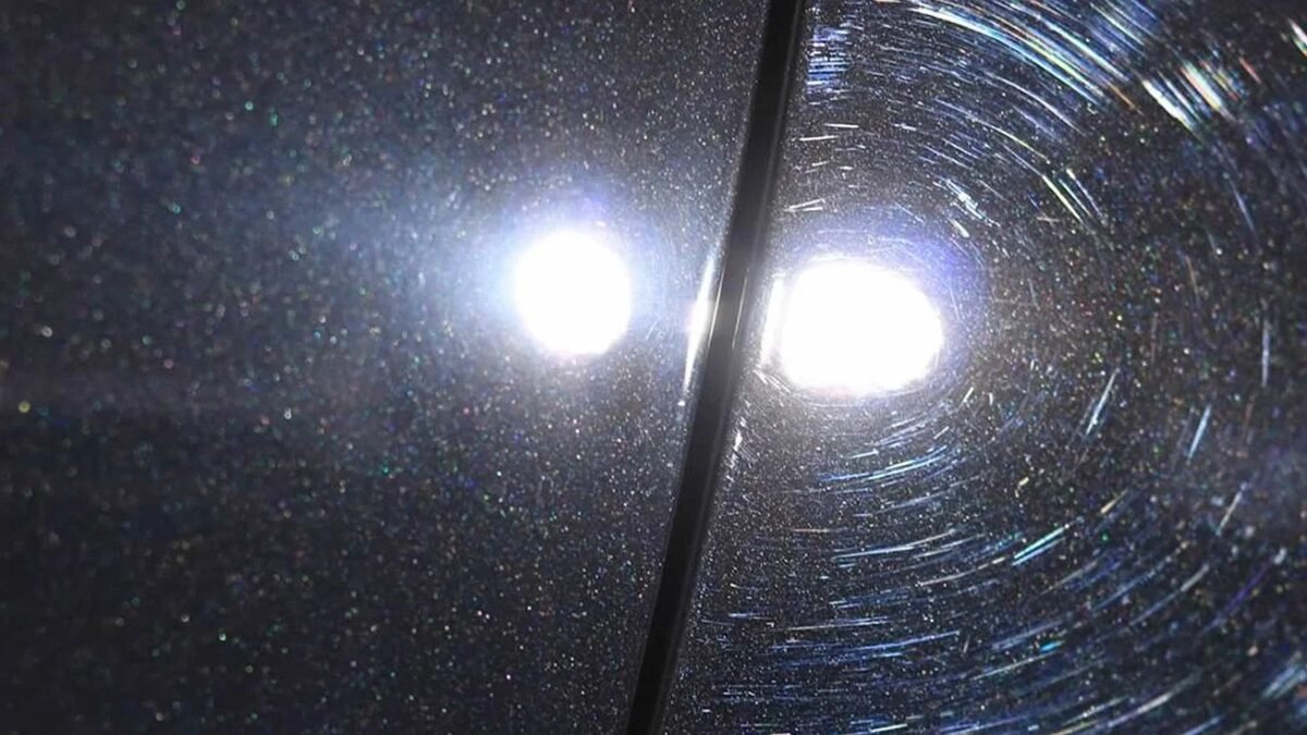 Swirl marks visible on dark car paint under direct sunlight