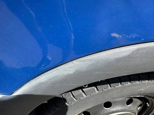 Faded grey plastic trim on car wheel arch